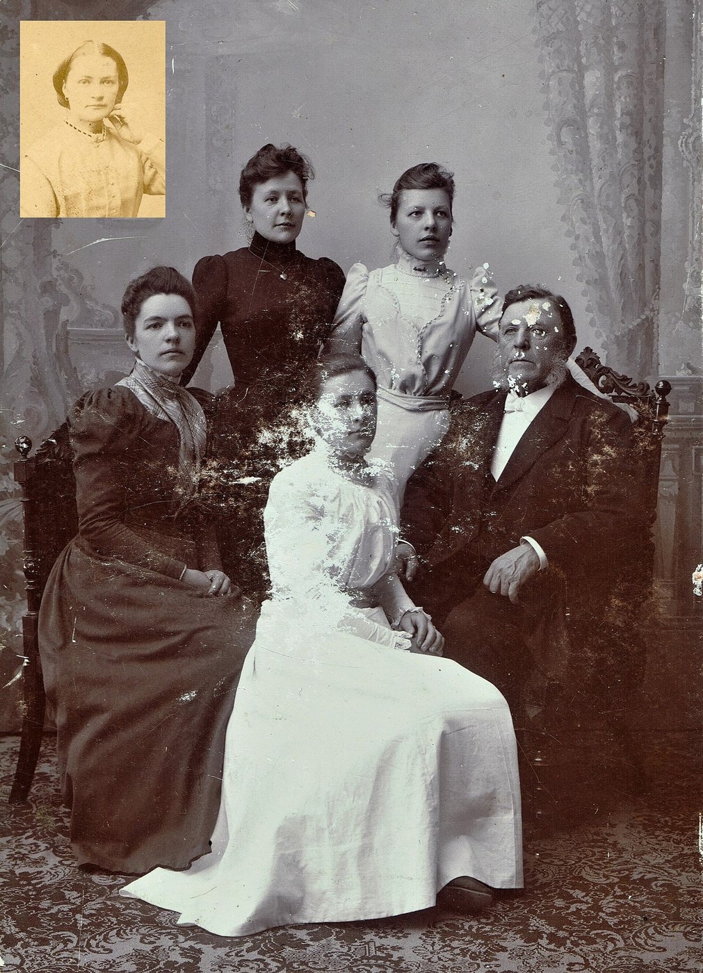 A family group portrait where silvering has eaten away most of the seated woman's face